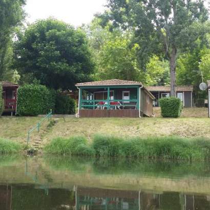 Chalet avec terrasse équipée de salon de jardin au bord de l'eau
